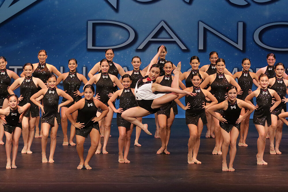 Large dance group performing on stage at CRU Dance Nationals
